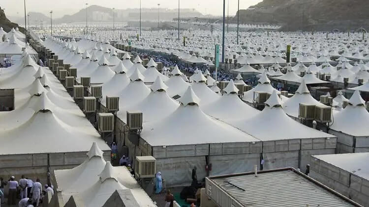 Suasana maktab di Mina saat musim haji, menampilkan tenda-tenda besar berwarna putih yang tertata rapi.