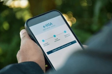 Close-up tangan memegang smartphone menampilkan e-visa Arab Saudi.jpg